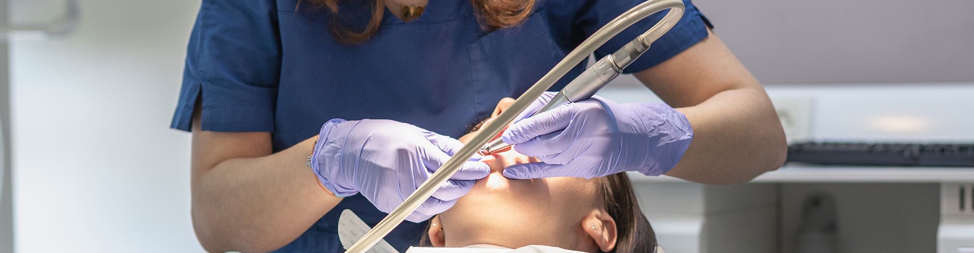 dentist using dental tools in woman's mouth